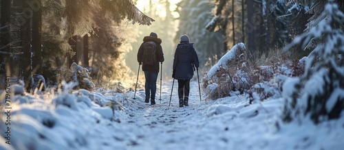 Winter sport in Finland nordic walking Senior woman and man hiking in cold forest Active people outdoors Scenic peaceful Finnish landscape. Copy space image. Place for adding text