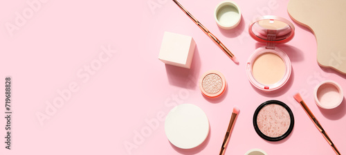 Decorative cosmetics, makeup brushes and podiums on pink background with space for text, top view