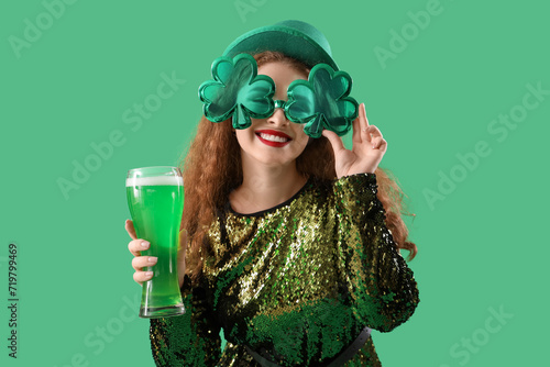 Young woman with beer on green background. St. Patrick's Day celebration