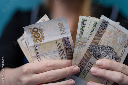 Kobieta wydaje pieniądze, gotówka polska pln w dłoniach 