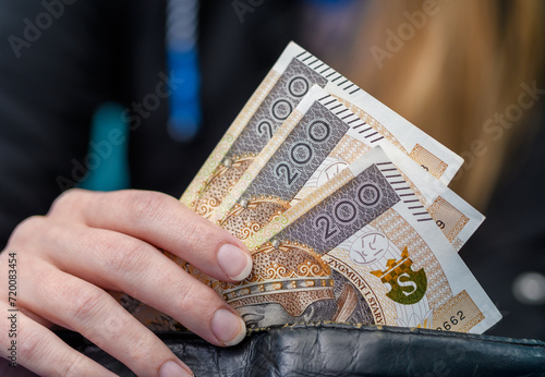 Kobieta chowa pieniądze do portfela, polska gotówka 