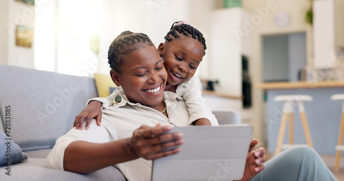 Family, woman with child and with tablet in living room of their home for social media. Technology or internet, streaming movie or bonding time and black mother with her daughter together happy