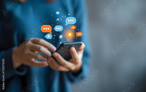 a person holds a smartphone with speech bubbles over it