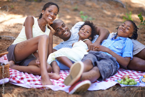 Portrait, relax and black family with forest picnic, hug or bonding in nature together. Love, food and children lying with parents in park for fruit, nutrition or healthy snacks for vacation in woods