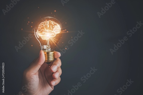 Hand Holding Light Bulb With Brain Inside Symbolizes Smart Thinking And Innovation