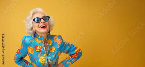 Very bright and happy old woman laughing in stylish glasses on a colored background. Close up shot of positive wrinkled old woman smiles toothily at camera wears glasses stylish outfit applies express