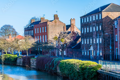 A view along the side of the River Welland in the centre of Spalding, Lincolnshire on a bright sunny day