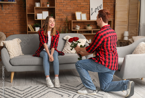 Young man with roses for his beloved girlfriend at home