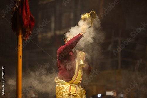 Ganga aarti, Portrait of young priest performing holy river ganges evening aarti at dashashwamedh ghat in traditional dress with hindu rituals. 