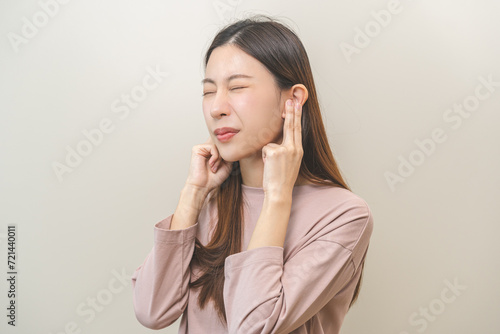 Tinnitus concept, sick asian young woman, girl have ear pain or earache, hand touch plug ear, suffering painful otitis from loud of noisy sound, inflammation. Health care nerve deaf eardrum disease.