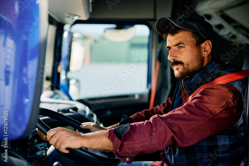 Professional truck driver driving on road.