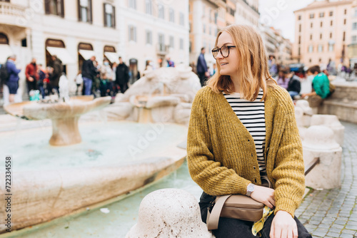 Happy Woman in glasses walking in the old town. Fontana della Barcaccia, little boat, Piazza di Spagna at Rome. Concept of happy vacations, traveling famous italian landmarks