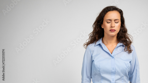 A contemplative young woman with closed eyes and curly hair