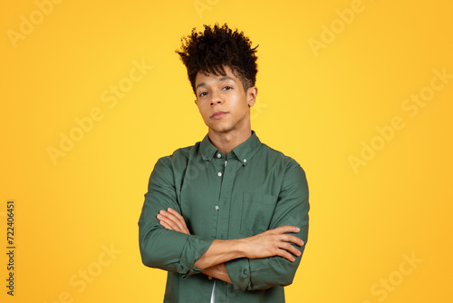 Confident young african american stylish guy posing on yellow