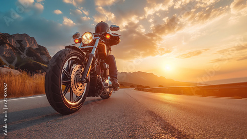 A motorcyclist rides fast on the road at sunset, banner with copyspace