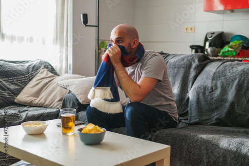 Man suffering watching sports on the sofa