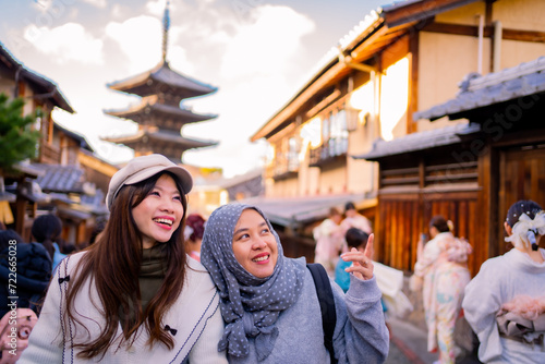 Travel, muslim travel, woman girl tourist Two Asian friends but different religions walking at Yasaka Pagoda and Sannen Zaka Street in Kyoto Japan, Yasaka Pagoda is the famous landmark and travel.