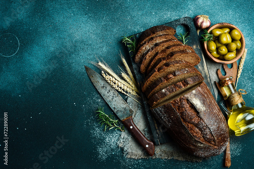 Rye sourdough bread with flax cut on a board. Fresh bread on a black background. Top view.