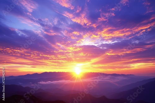 Amazing colorful sunset or sunrise landscape in mountain range with purple pink orange blue sky and white clouds