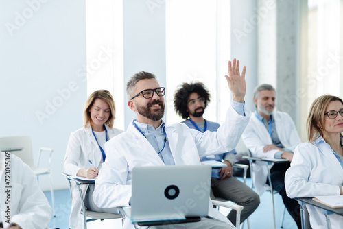 Medical team on conference, doctor asking question to speaker. Medical experts attending an education event, seminar in board room.