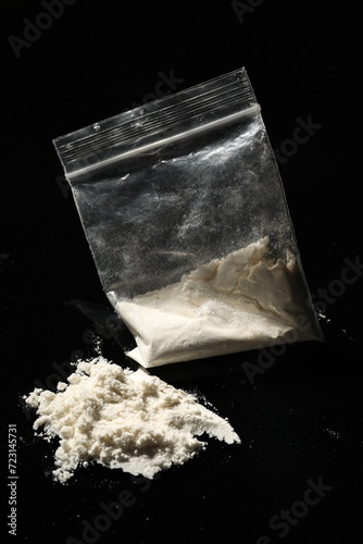 Drug addiction. Plastic bag with cocaine on black background, closeup