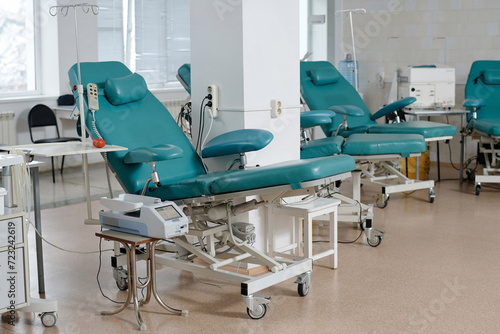 Interior of clean and empty blood transfusion center with armchairs for donors and medical equipment