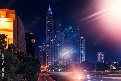 Night cityscape of center Dubai, aerial top view. Skyscrapers illuminated and highway of UAE