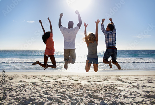 Jump, beach or back of friends on holiday vacation in the air together in summer at sea. Outdoor, group or excited men with happy women in fun celebration of freedom by ocean, sand, nature for travel