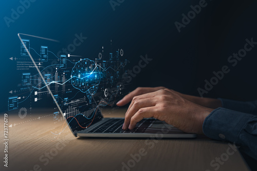 Businessman using laptop with digital screen about brain of AI and exponential graph. Digital information technology and artificial intelligence concept.