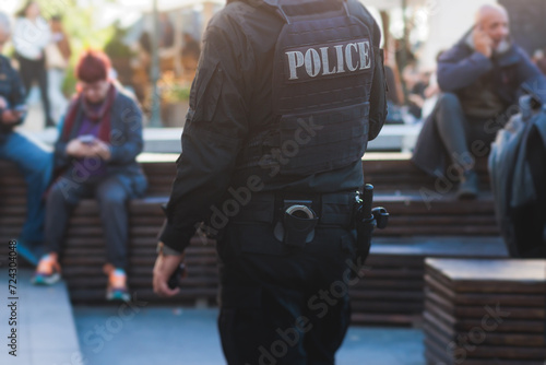 Police squad formation on duty maintain public order in the european city streets, group of policemen patrol in body armor with "Police" logo on uniform, Europe, policeman in bulletproof vest