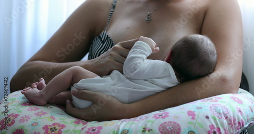 Newborn baby being held by mother after birth, infant little hand holding mother finger