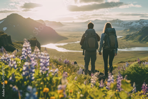 A couple of young hikers with heavy backpacks admiring scenic view of spectacular Icelandic nature. Breathtaking landscape of Iceland. Hiking by foot.