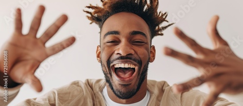 Close up vertical portrait of a happy young man expressing himself with hand gestures.