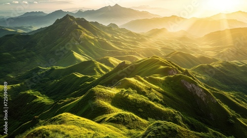 a green mountains with sun shining through the mountains