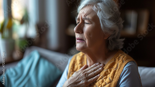 Old woman senior holding his chest with a sad and pained expression