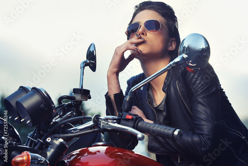 Bike, leather and woman smoking in city with sunglasses for travel, transport or road trip as rebel. Fashion, model and nicotine with attitude on classic or vintage bike for transportation or journey