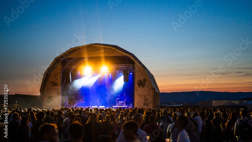open air musical event stage with a blue sky during sunset