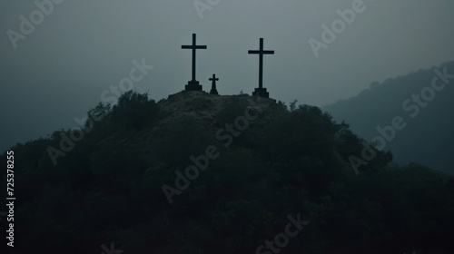 Three crosses sit on top of a hill, creating a dark graveyard scene in the fog.