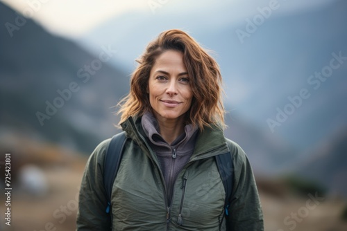 Portrait of a beautiful woman hiker with backpack in the mountains