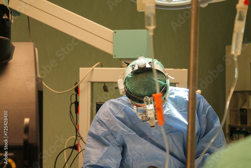 Doctors are surgery to patient at operating room. the doctor's head with special glasses for microsurgery