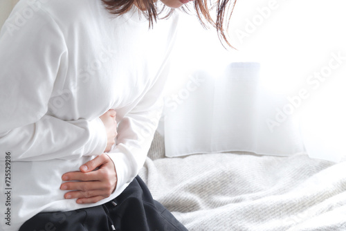お腹を抑える女性 腹痛イメージ