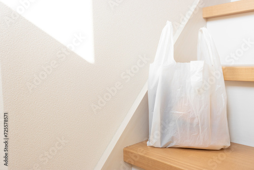 階段に置かれた食品の入ったレジ袋のイメージ
