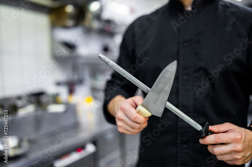 Chef sharpening a kitchen knife with Honing steel