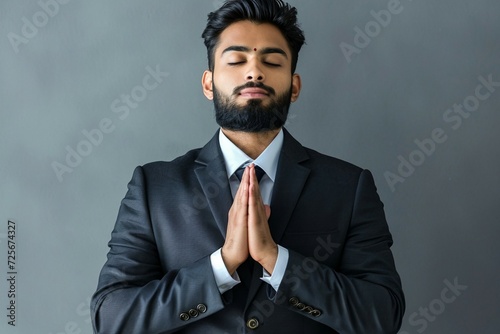 a man with his eyes closed and his hands together in prayer