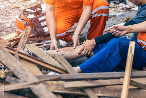 paramedic medical emergency team working help labor accident at dirty construction site leg injury painful tetanus risk