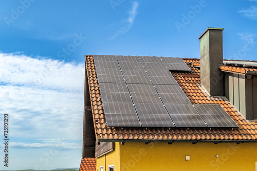 Solarzellen auf Hausdach vor blauem Himmel