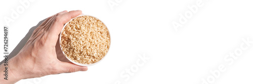 A bowl of uncooked brown rice, isolated against a white background. Healthy, savory dish includes whole grains like jasmine and basmati, showcasing a dieting Asian cuisine. Horizontal banner