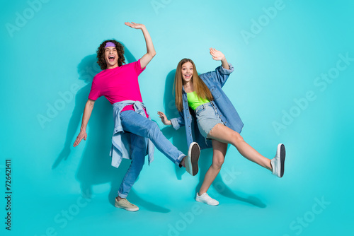 Full length body photo of two hipsters have some fun partying in night club for extraordinary teenagers isolated on cyan color background