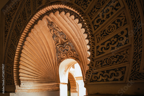 Detail of a window arch decorated in Moorish style in the famous Nasrid Palace of the Alcazaba, Malaga, Spain.