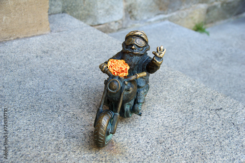 WROCLAW, POLAND - 16 JUN 2018: One of Wroclaw's gnomes on a motorbike. The bronze figures dwarfs are around 30 cm tall and are placed throughout the city centre of Wroclaw